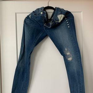 Levi’s jeans with some rips and embellishments.